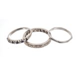 Three rings - to include a diamond eternity ring with a full band of single cut diamonds,