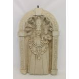 Carved stone niche of arched form, with Holy mother and child group, in architectural border,