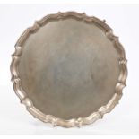 Large 1920s silver salver of circular form, with piecrust border, on four pad feet (Chester 1925),