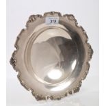 Contemporary silver fruit dish of circular form, with shell and scroll border,