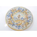 Early 19th century Italian Majolica charger painted with Cupid and buildings in landscape,