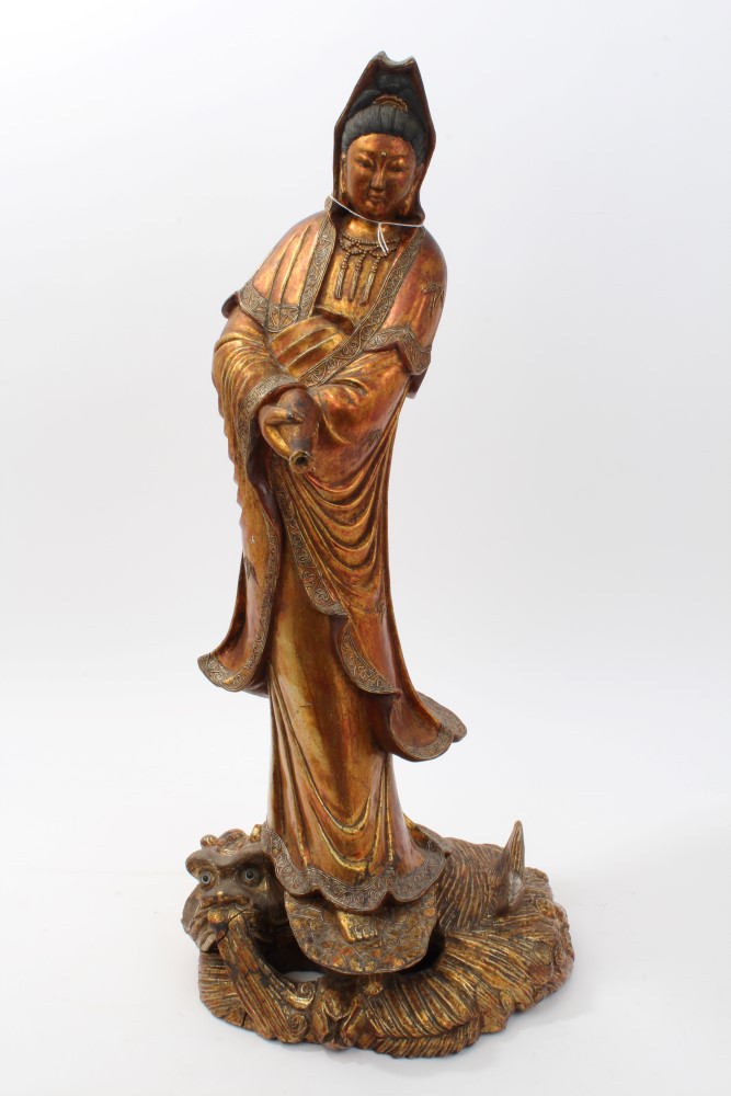 Large Chinese and giltwood figure of Guanyin in contemplative pose, holding a vessel,