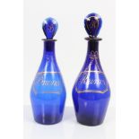 Two late Georgian Bristol blue decanters with pear-shaped stoppers with gilt painted Rum and Brandy