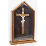 Early 20th century carved ivory and walnut crucifix housed within glazed arched case with rear door,