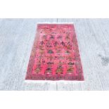 Unusual 1980s Afghan rug - with claret field punctuated by stylised helicopter,