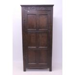 Oak standing cupboard with lunette carved frieze enclosed by single panel door,
