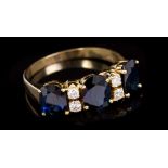 Sapphire and diamond ring with three oval mixed cut blue sapphires interspaced by four brilliant