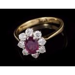 Ruby and diamond cluster ring with an oval mixed cut ruby, measuring approximately 7.25mm x 5.