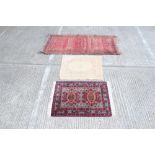 Pakistani rug - brick-red field with row of five medallions within borders, 190cm x 104cm,