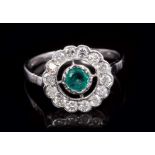 Emerald and diamond cluster ring with central round mixed cut emerald in an openwork design,