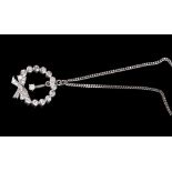 Diamond pendant with a single brilliant cut diamond suspended within a diamond wreath tied with a