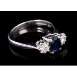 Sapphire and diamond three stone ring with an oval mixed cut blue sapphire flanked by two brilliant