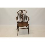 19th century ash and elm wheelback elbow chair with solid saddle seat on slender splayed turned