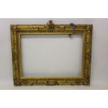 A Victorian gilt and gesso frame with heraldic mount - internal size 67cm x 93cm