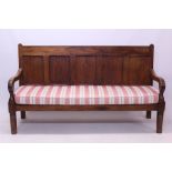 Large 19th century pine settle with panelled back and overscroll arms,