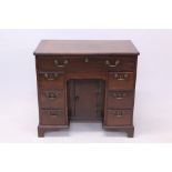 Good George II mahogany kneehole desk - the broad crossbanded moulded top with re-entrant angles