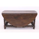 Large 17th century-style oak double gateleg table - the elliptical hinged top on barley-twist