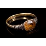 Georgian dress ring with a foil-back orange stone with a rose cut diamond to each shoulder,