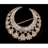 Victorian diamond crescent brooch with a pierced design and set with graduated old cut diamonds,