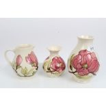 Two Moorcroft pottery vases decorated in the Hibiscus pattern on magnolia ground and a matching jug