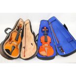 Two children's violins with bows,