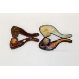 Two late 19th century meerschaum pipes carved in the form of a hand holding the pipe bowl,