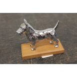 Chrome plated Scottie dog car mascot mounted on wooden plinth,