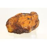 Massive raw Baltic amber specimen honey-toned, on flat base,