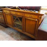 A 5' 7" French walnut and strung sideboard with three frieze drawers, central glazed panel door