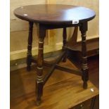 A 23" diameter stained oak tavern style occasional table with turned supports and X-stretcher