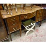 A 4' 5" Edwardian mahogany and strung break bow front kneehole dressing table with shaped frieze