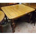 An early 20th Century polished oak draw-leaf dining table, set on turned supports and X-stretcher