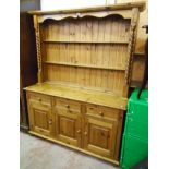 A 4' 10" modern waxed pine two part dresser with two shelves and flanking half barley twist columns,