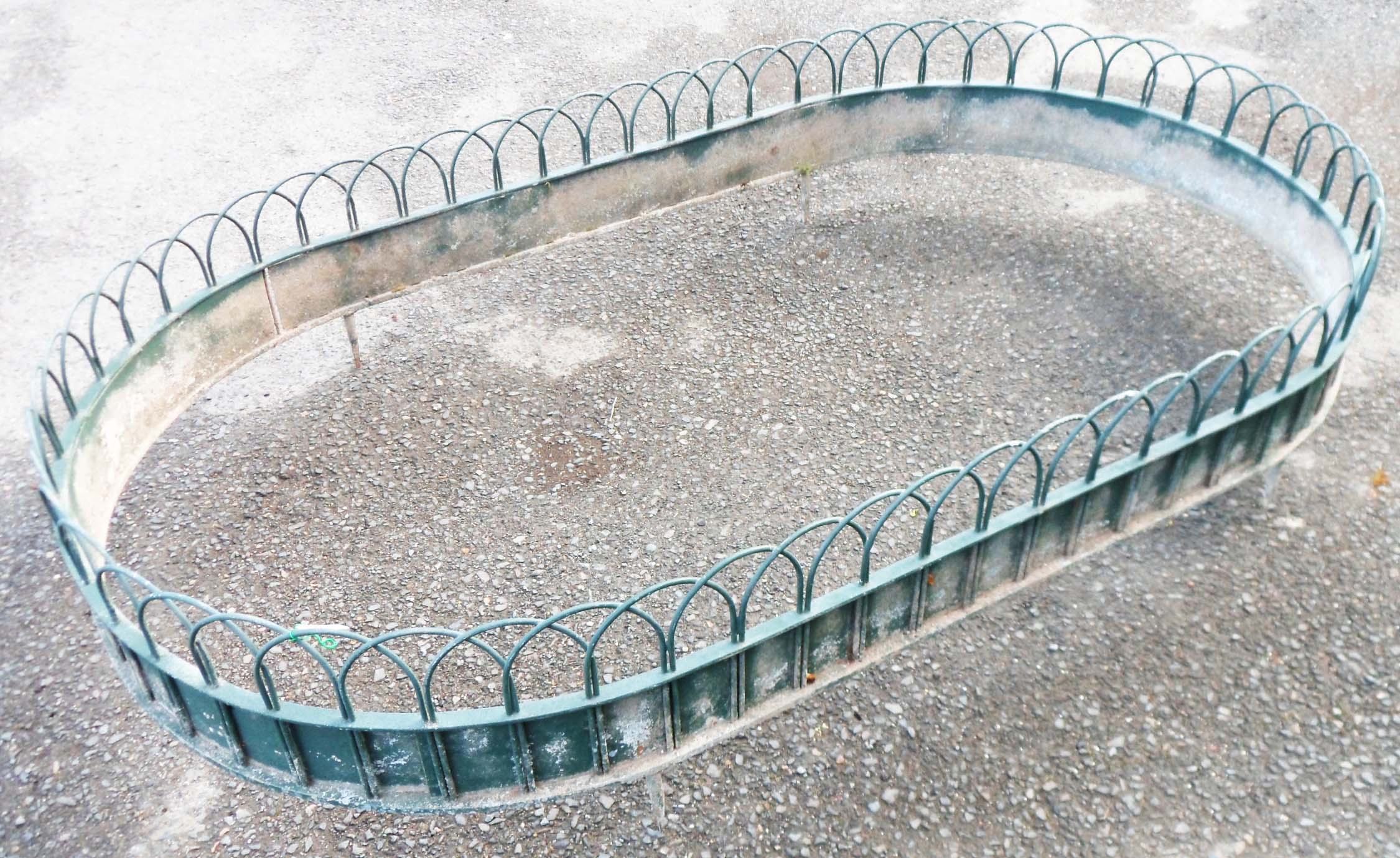 A 6' 1" 20th Century painted metal decorative garden border of oval design with arched wirework