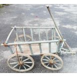 A 4' old painted wood and iron mounted handcart with slatted sides, tiller bar to front axle and