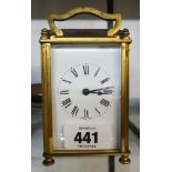 An early 20th Century brass and bevelled glass cased carriage timepiece with shaped swing handle and