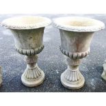 A pair of 18 1/2" diameter concrete garden urns of semi reeded design, set on egg and dart bases