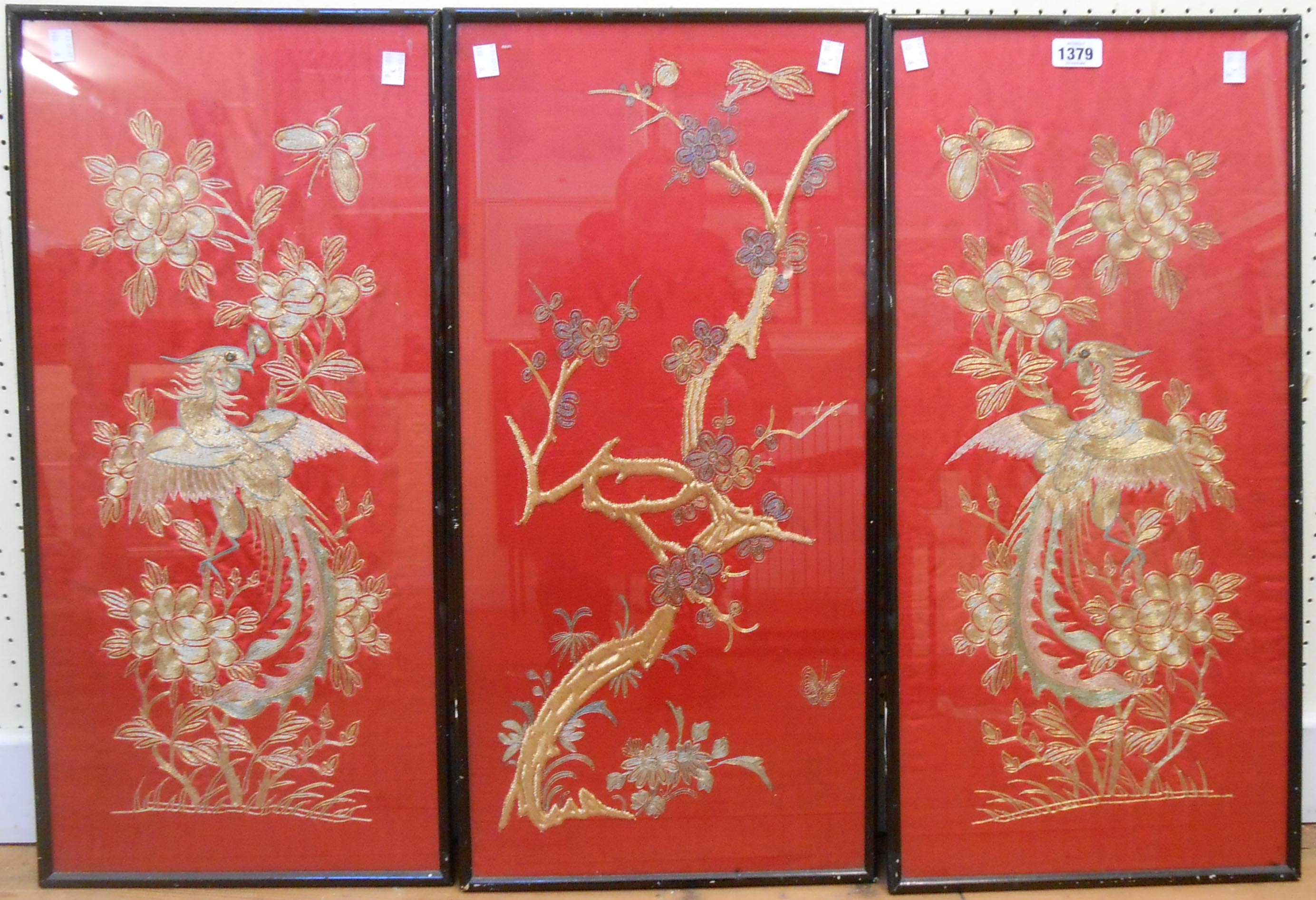 A 20th Century ebonised framed triptych of gold coloured embroidery on red ground, depicting