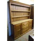 A 6' Victorian pine two part dresser with two shelf open plate rack over a base with three central