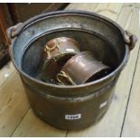 A rustic coppered tin pot with wrought iron swing handle - sold with a pair of small copper pots