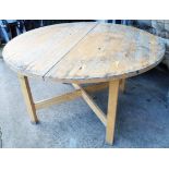 A 4' 4" diameter painted wood extending dining table, set on square supports with X-stretcher