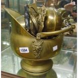 A brass coal helmet containing various small items of metalware, including bottle openers, dog