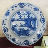 A 13 1/2" diameter antique Dutch delft charger with chinoiserie panel within a stylized floral