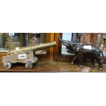 A cast bronzed spelter elephant - trunk broken - sold with a cast brass cannon on wooden gun