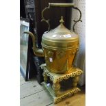 A large brass faceted kettle with scroll handle and embossed stylized trees and flowers