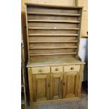 A 4' waxed pine dresser with three shelf open plate rack to top, over three frieze drawers and