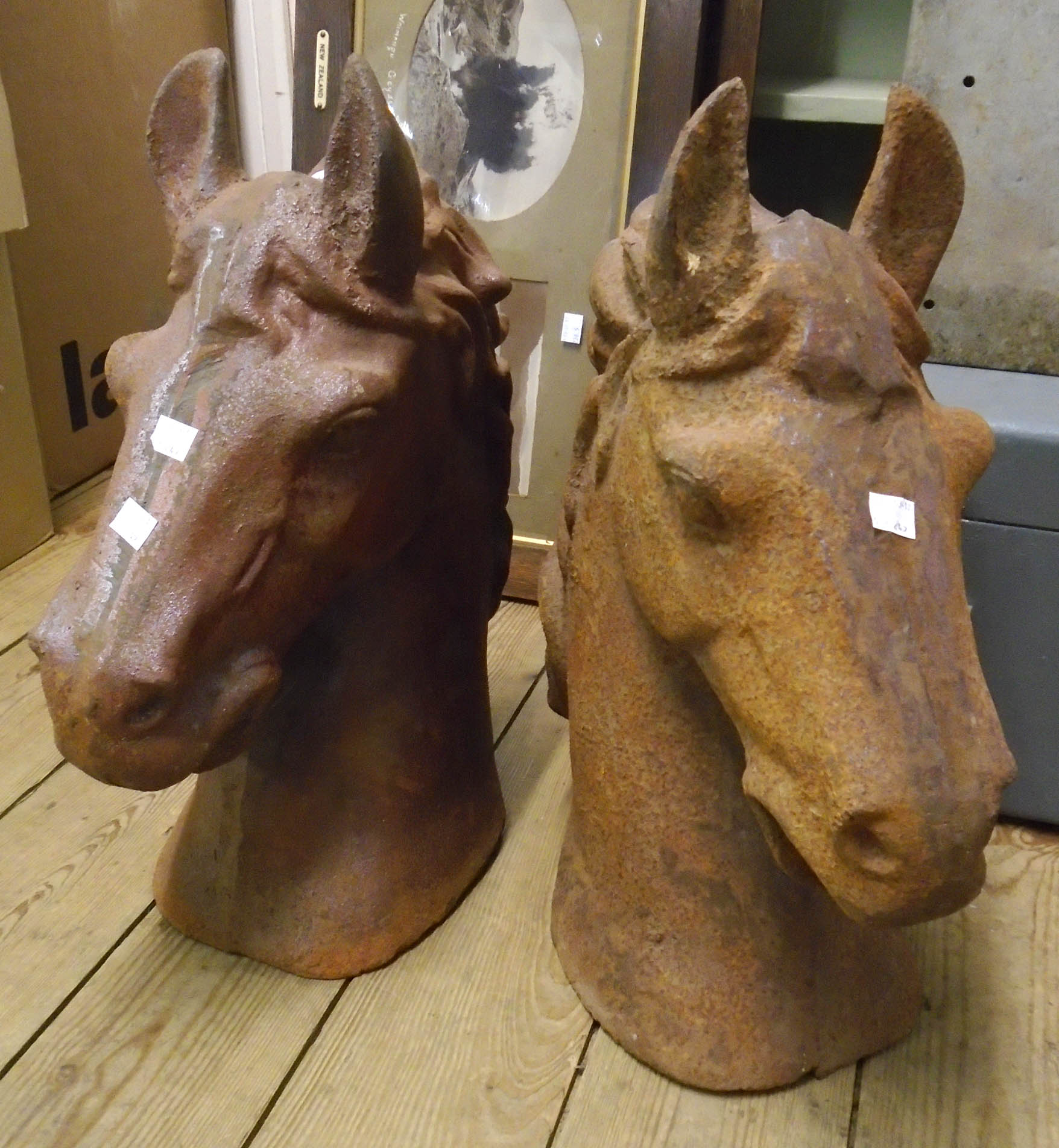 A pair of cast iron horse heads with rusted finish