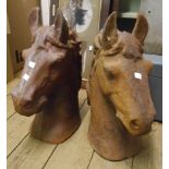 A pair of cast iron horse heads with rusted finish
