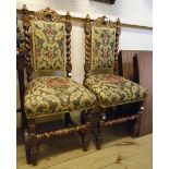 A pair of Jacobean style carved oak framed panel back dining chairs with flanking barley twist