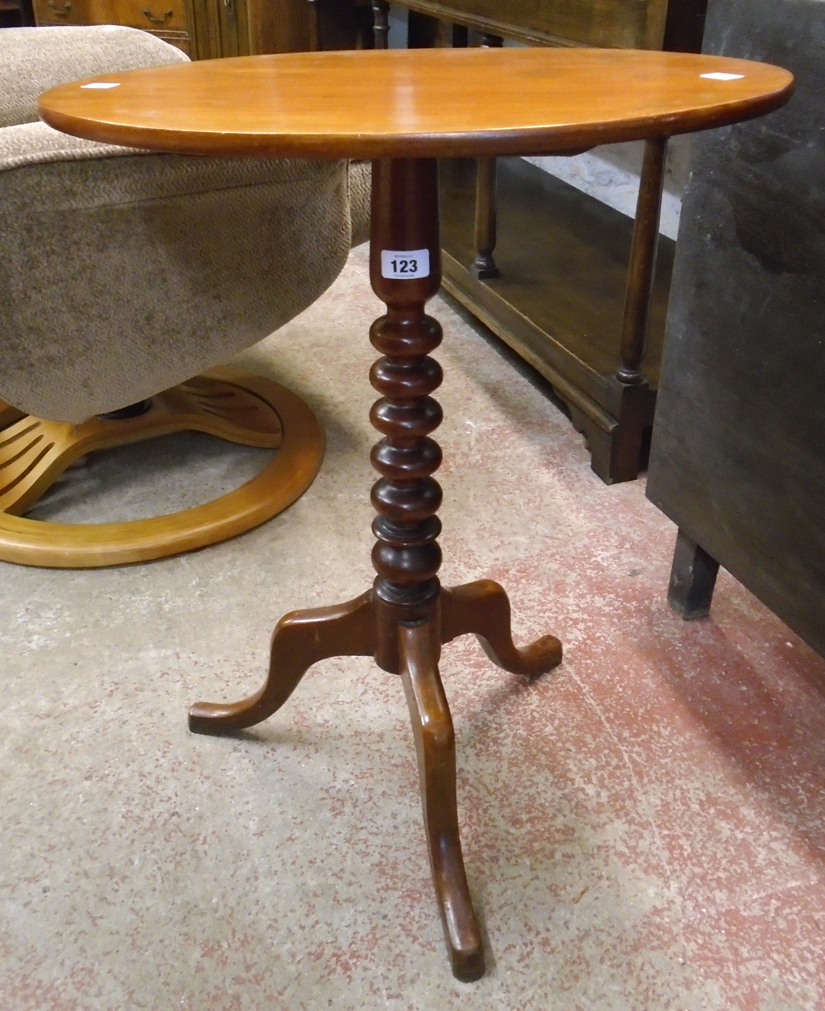 A Victorian mahogany pedestal wine table with oval tilt-top, set on bobbin turned pillar and